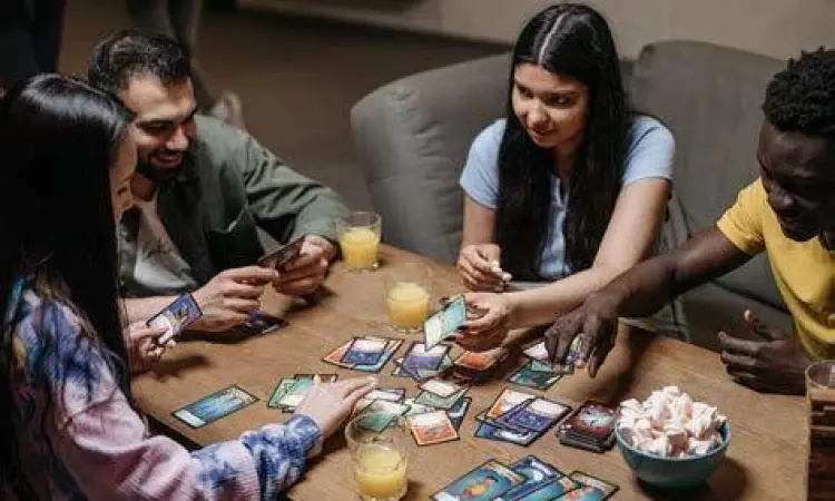 Sekelompok orang bermain kartu bersama dengan ceria